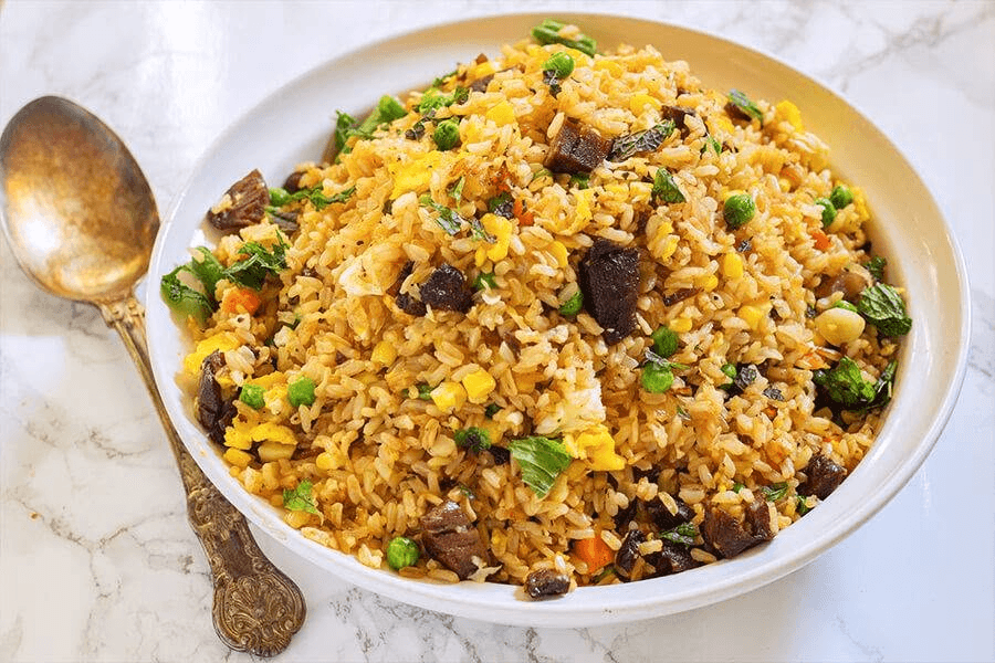 A bowl of fried rice with vegetables and egg