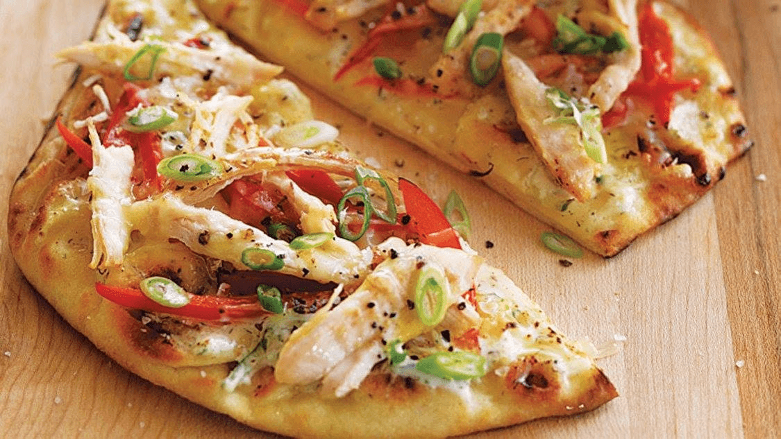 Freshly baked flatbread with chicken, peppers and spring onions